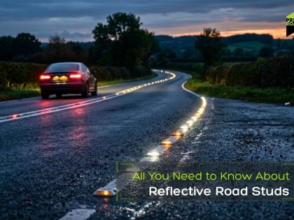A car drives on a wet, rural road at dusk, with reflective road studs marking the centerline; text reads, All You Need to Know About Reflective Road Studs.