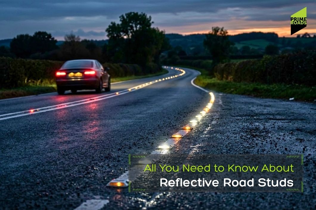 A car drives on a wet, rural road at dusk, with reflective road studs marking the centerline; text reads, All You Need to Know About Reflective Road Studs.