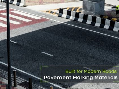 A crosswalk on a street with a sign indicating the use of modern pavement marking materials for improved road design.