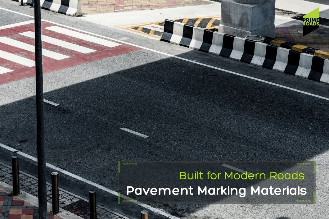 A crosswalk on a street with a sign indicating the use of modern pavement marking materials for improved road design.